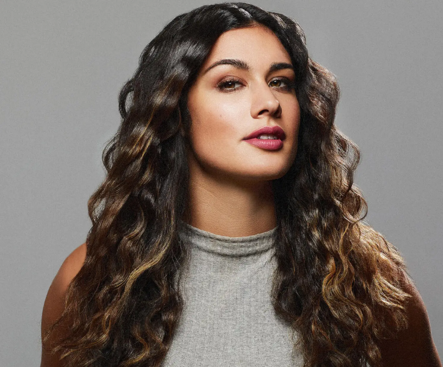 «Жінка з довгими хвилястими локонами після укладання стайлером Revlon.