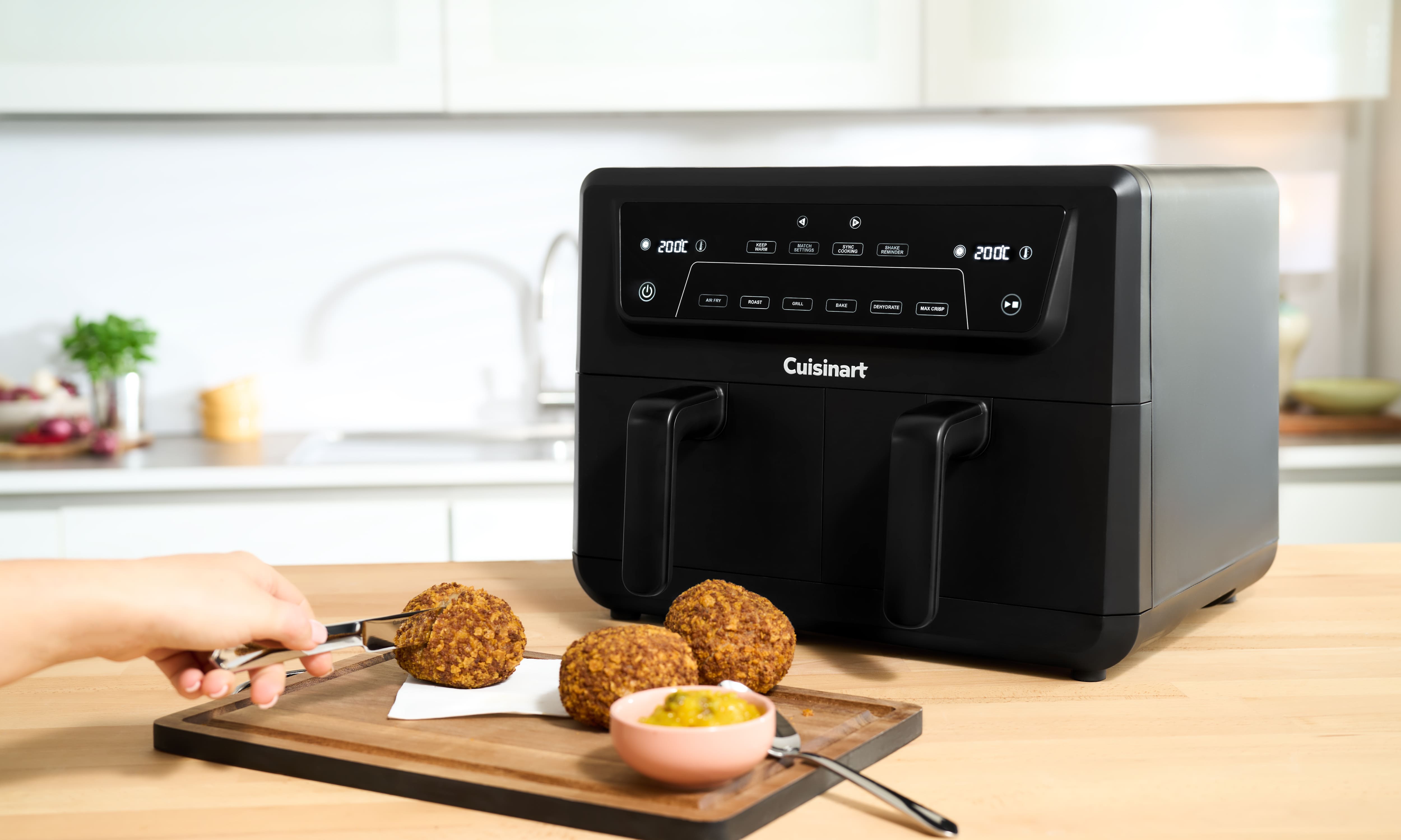Подвійна аерофритюрниця Cuisinart на кухні поруч із готовими стравами