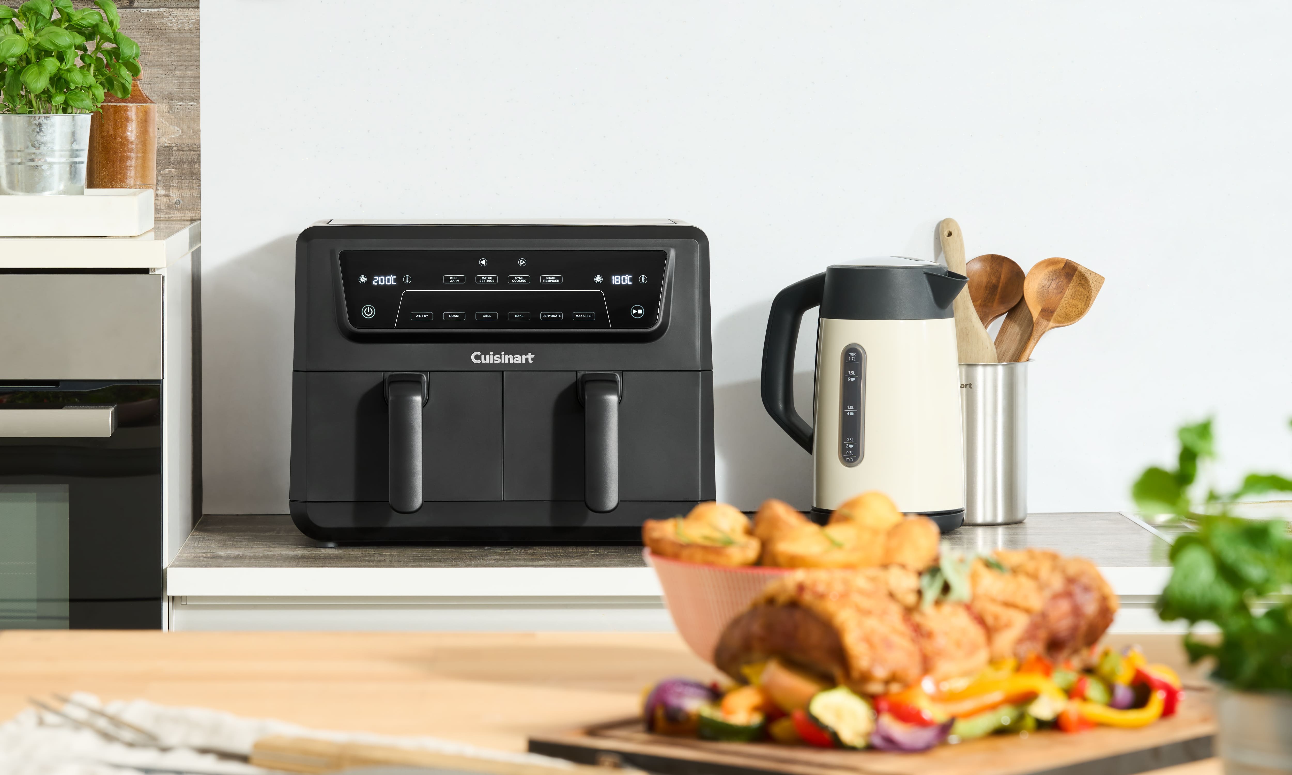 Аерофритюрниця Cuisinart на кухні поруч із готовою стравою та електричним чайником