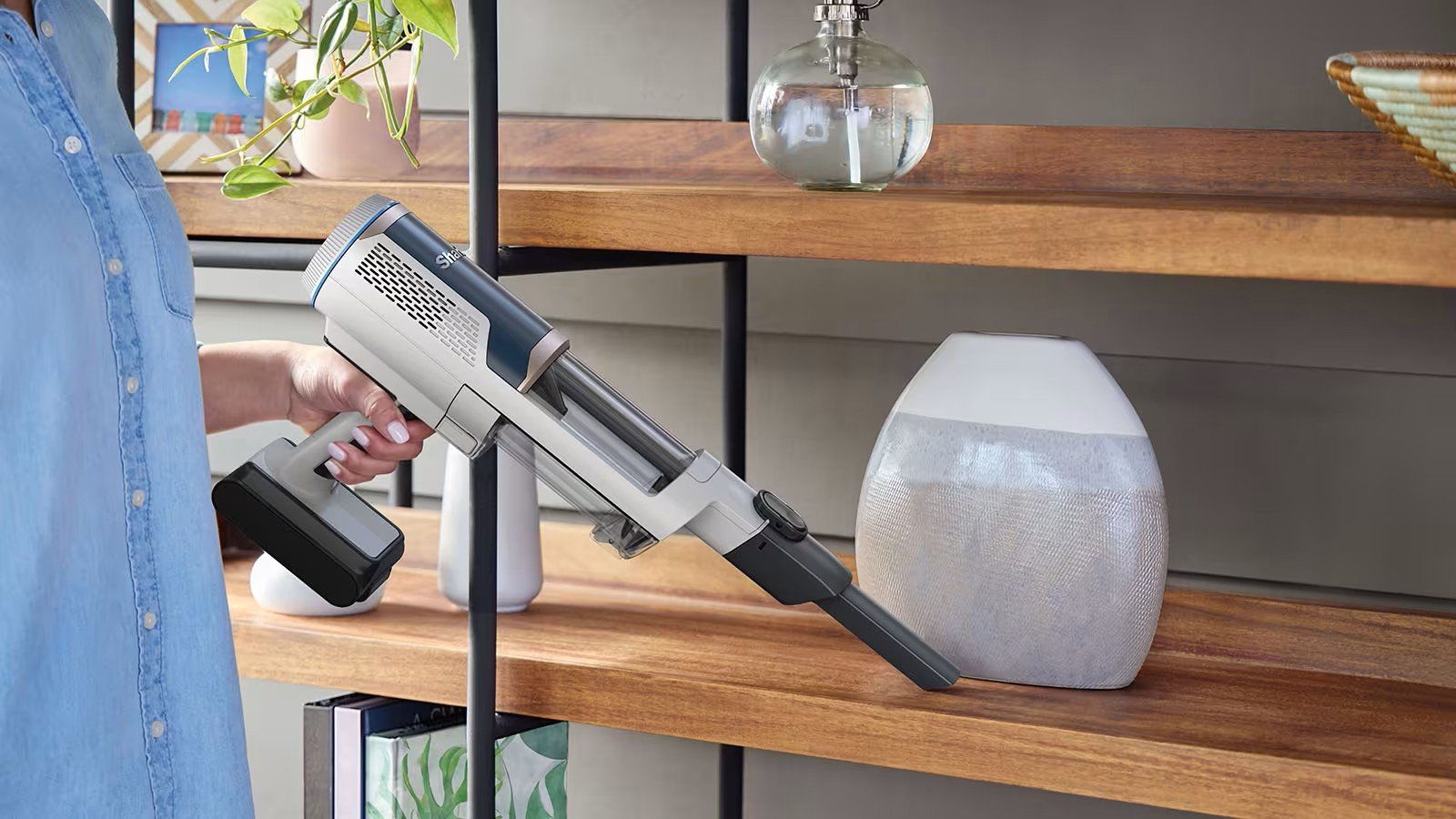 Бездротовий пилосос Shark BU3521EU у ручному режимі очищує полицю від пилу за допомогою щілинної насадки